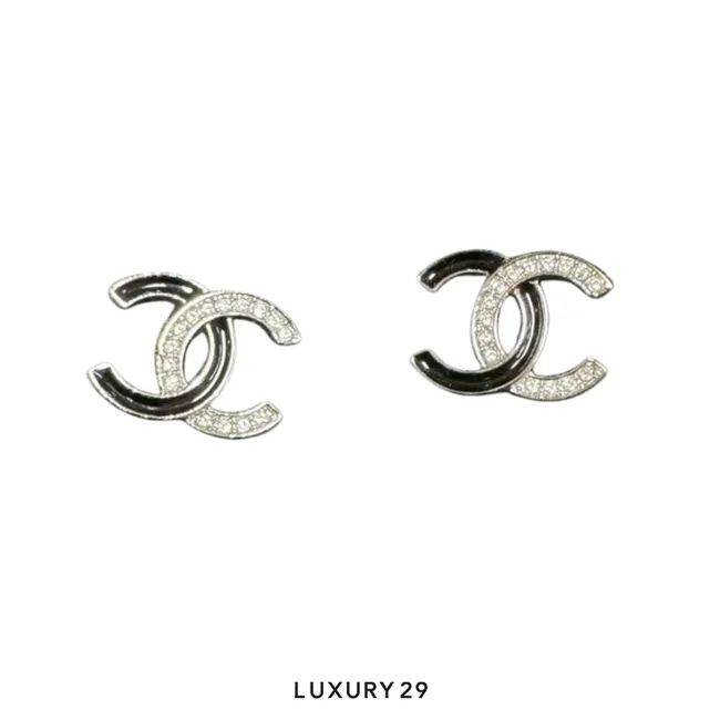 Chanel CC stud earrings feature a black and silver bicolor design enhanced with clear crystal accents